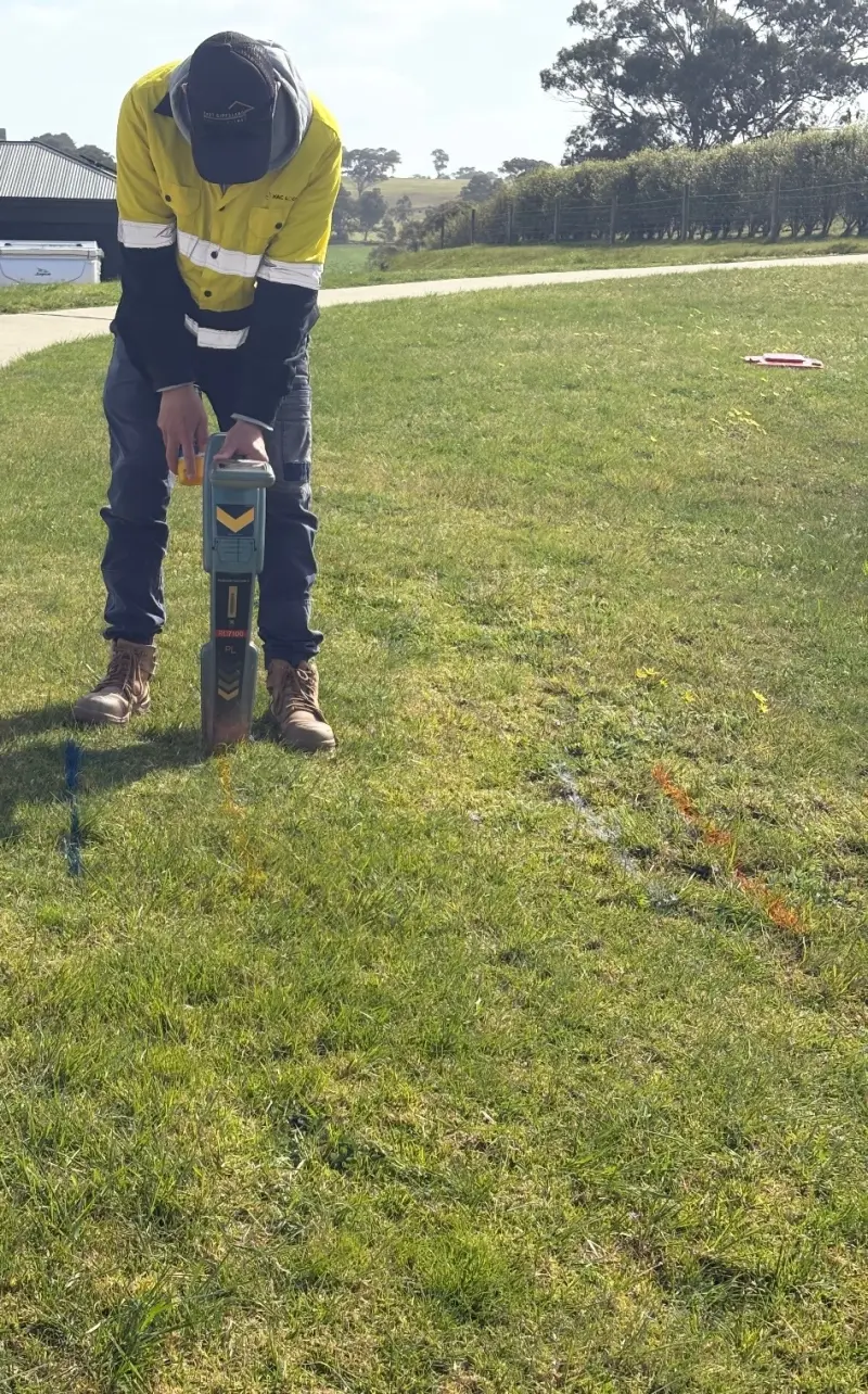 Joel from MAC Locating tracing an underground service on a grassed block