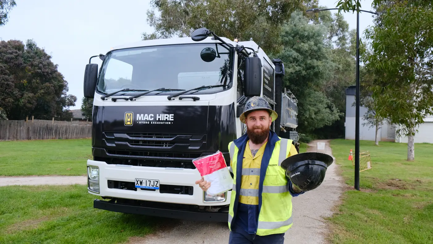 MAC operator beside the hydro excavation truck